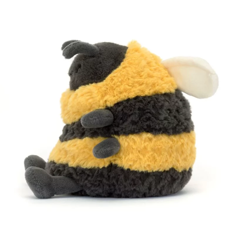 Side view of the Jellycat Albee Bee, showcasing its soft cream wings, charcoal legs, and bumblebee stripes.