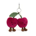 Front view of the Jellycat Amuseable Cherries Bag Charm, featuring two plush cherries with stitched smiles, fine cord legs, and a green suedette leaf, attached to a silver clasp.