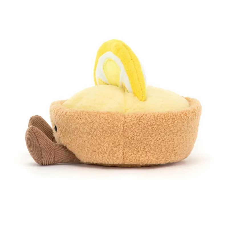 Side view of the Jellycat Amuseable Collette Tarte Au Citron, highlighting its textured pastry crust, lemon slice decoration, and fine cord legs.
