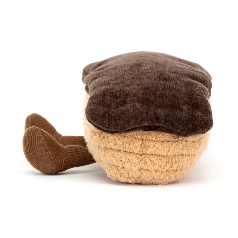 Side view of the Jellycat Amuseable Étienne Eclaire, highlighting the soft beige choux pastry texture and deep brown icing topping.