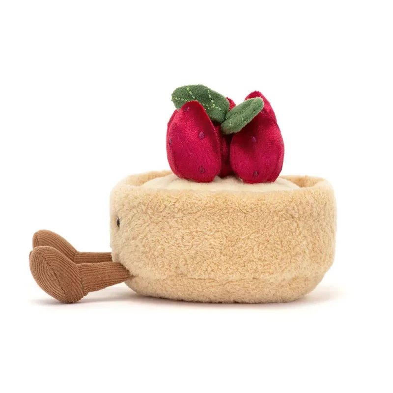 Side view of the Jellycat Amuseable Fleurette Tarte Aux Fraises, highlighting its fluffy texture, brown corduroy legs, and stacked strawberry decoration.