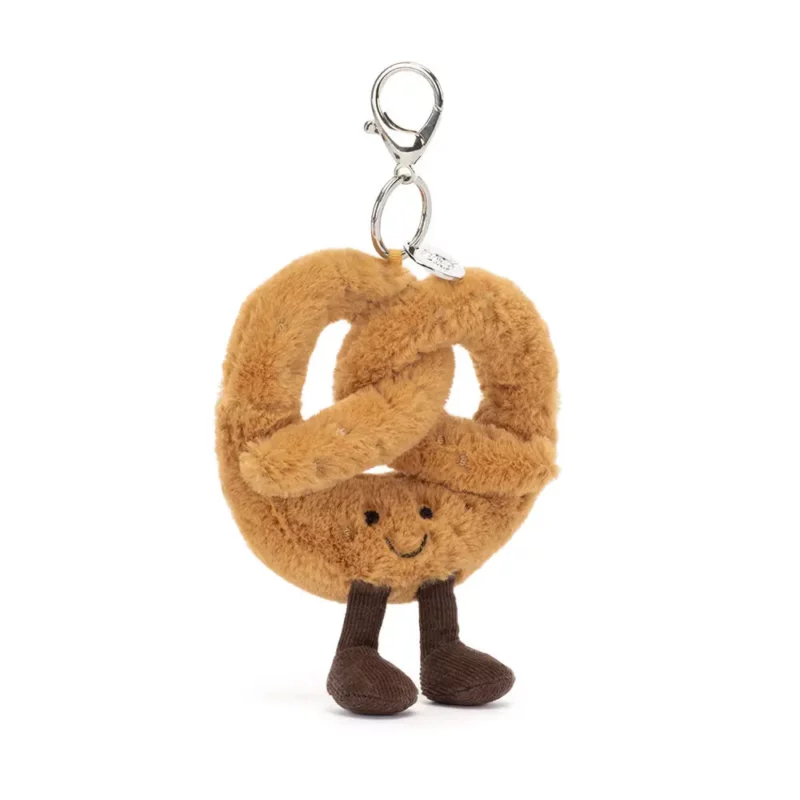 Front view of the Jellycat Amuseable Pretzel Bag Charm, showcasing its golden brown plush design with fine cord legs and a silver claw clip.