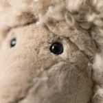 Detail view of the Jellycat Ramsley Sheep, focusing on its shiny black eyes and soft snout.