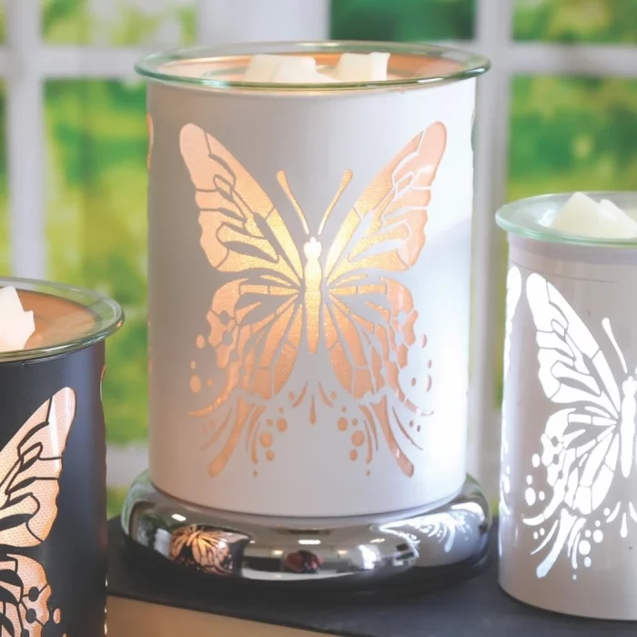 White Silhouette Butterfly Aroma Electric Wax Melt Burner displayed in a cosy setting, casting a warm glow through its detailed butterfly design.