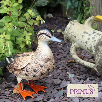 Brown Duck Metal Garden Ornament displayed in a leafy garden setting beside a rustic stone watering can.
