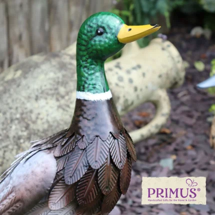 Duck Metal Garden Ornament displayed in a garden with a stone jug and bark mulch background.
