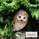 Owl Metal Garden Ornament perched on a tree branch surrounded by green foliage.