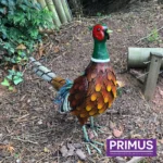 Pheasant Metal Garden Ornament positioned outdoors with vibrant tail feathers and textured detail.