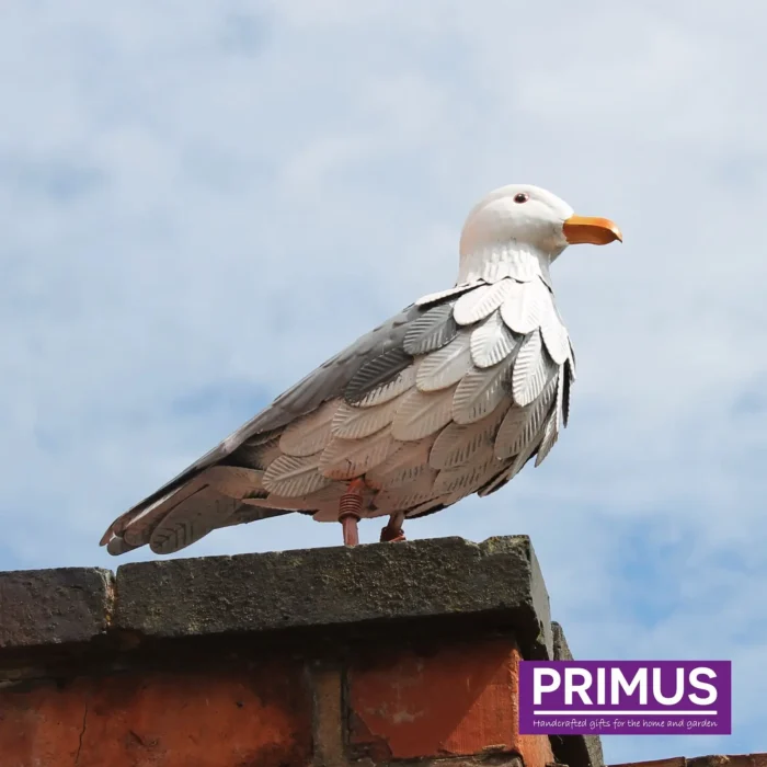 Seagull Metal Garden Ornament perched on a brick wall with the sky in the background.