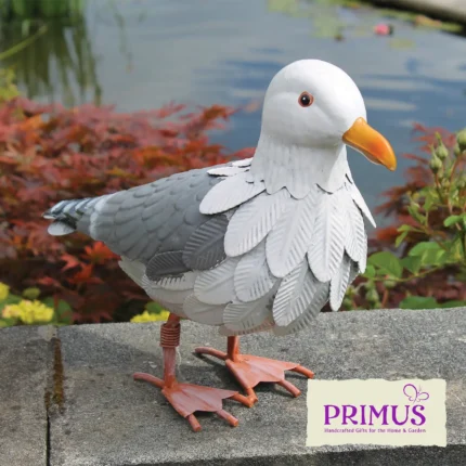 Seagull Metal Garden Ornament displayed beside a pond, with detailed metal feathers and bright orange beak.