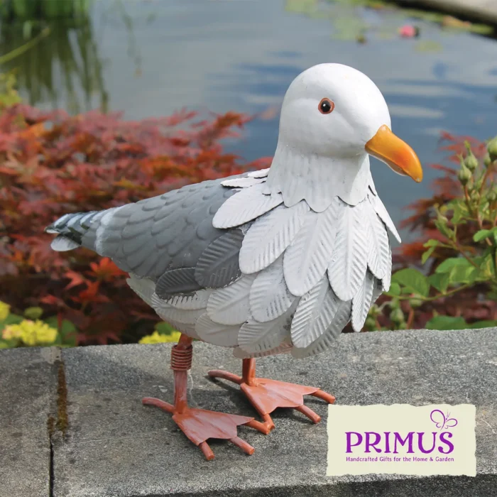 Seagull Metal Garden Ornament displayed beside a pond, with detailed metal feathers and bright orange beak.