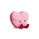 Front view of Jellycat Amuseable Colette Heart Macaron, showcasing its light pink heart shape, red feet, and stitched smile.