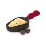 Front view of Jellycat Amuseable Raclette, featuring her smiling cheesy face nestled inside a plush dark pan with a red handle and dangly cordy feet.