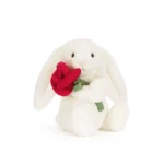 Front view of Jellycat Bashful Cream Bunny with Rose, holding a red plush flower and showcasing her soft cream fur and long floppy ears.