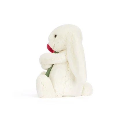 Side view of Jellycat Bashful Cream Bunny with Rose, highlighting her seated pose, gentle expression, and floral detail.