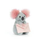 Front view of Jellycat Koala With Message, holding a soft pink envelope and showing its fluffy pink ears and charcoal nose.