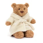 Alternative front view of Jellycat Bartholomew Bear in cream bathrobe with hood down and smiling face.