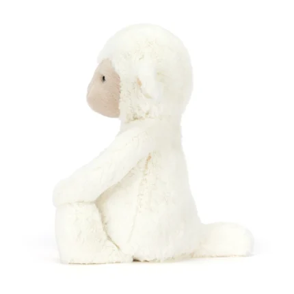 Side view of Jellycat Skipson Lamb showing profile of face, plush cream fur, and floppy limbs.