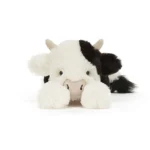 Alternative front view of Jellycat Smudge Cow lying down with front hooves extended and a calm facial expression.