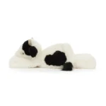 Side view of Jellycat Smudge Cow showing black patch detail, black tail tuft, and relaxed lounging posture.