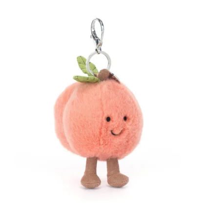 Front view of Jellycat Amuseable Peach Bag Charm with velvety blush fur, stitched smile, soft brown cord legs and silver clasp attachment.