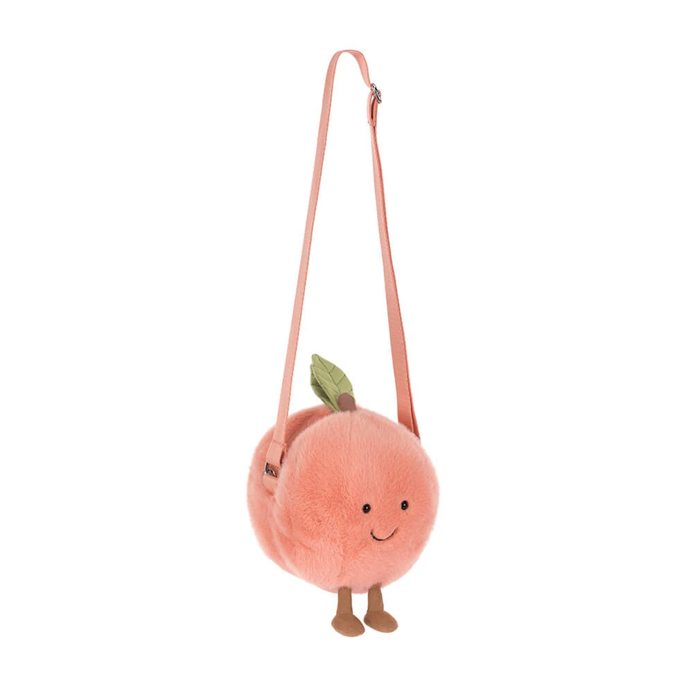jellycat-amuseable-peach-shoulder-bag-front Front view of Jellycat Amuseable Peach Shoulder Bag with soft peach fur, stitched smile, brown cord legs and adjustable strap.