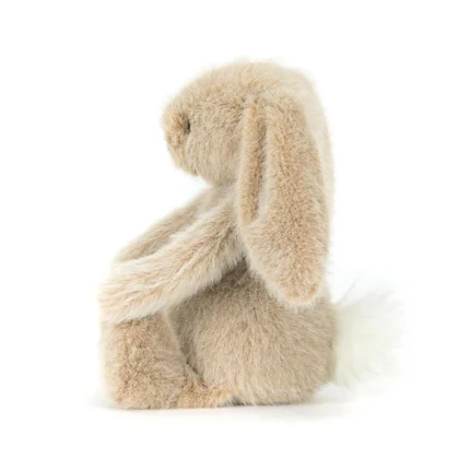 Side view of Jellycat Oat Flufflet Bunny showing plush oat beige fur, long floppy ear and fluffy cream tail.
